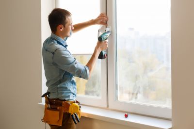 A handyman fixing a window latch