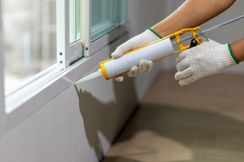 Technician sealing a window frame